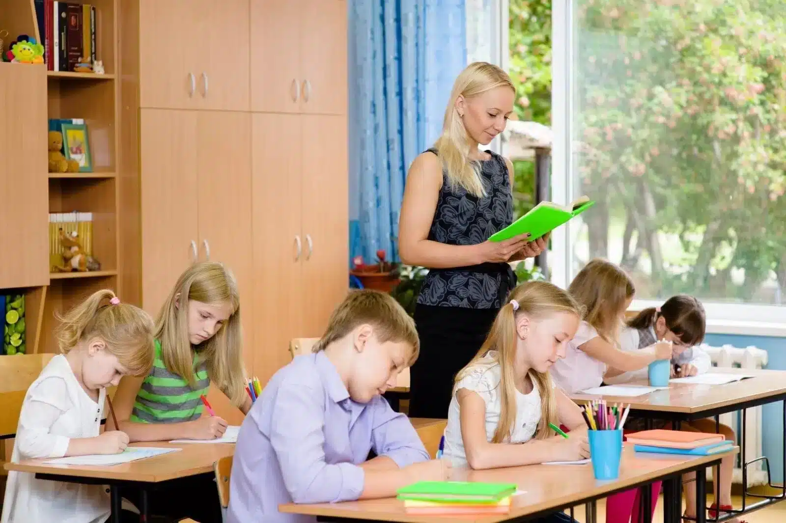 Teacher walking around student working with the paper