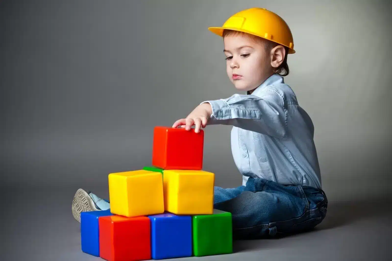 Boy wearing a construction Had Playing with Blocks