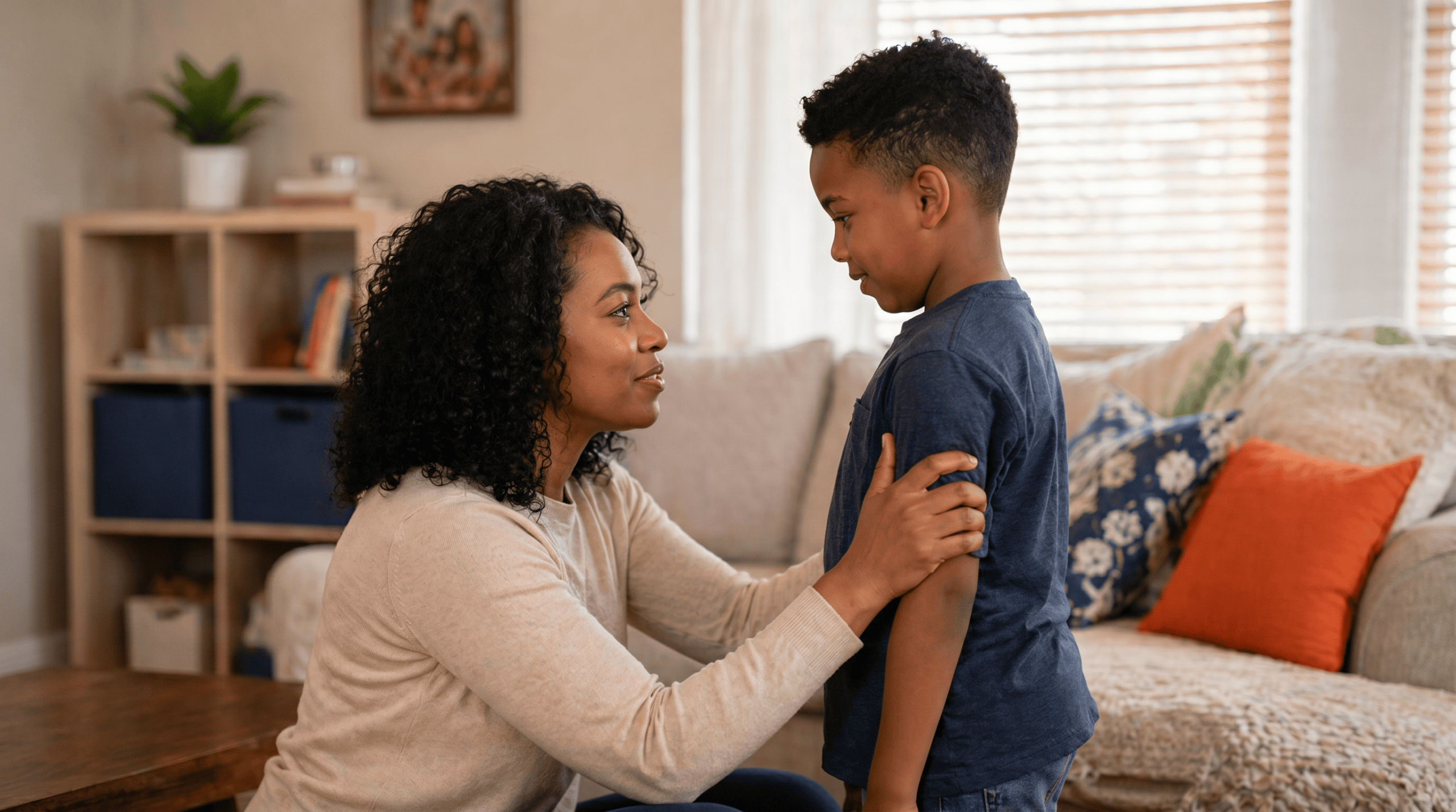 Child with special needs smiling while working on schoolwork at a desk with a supportive tutor nearby