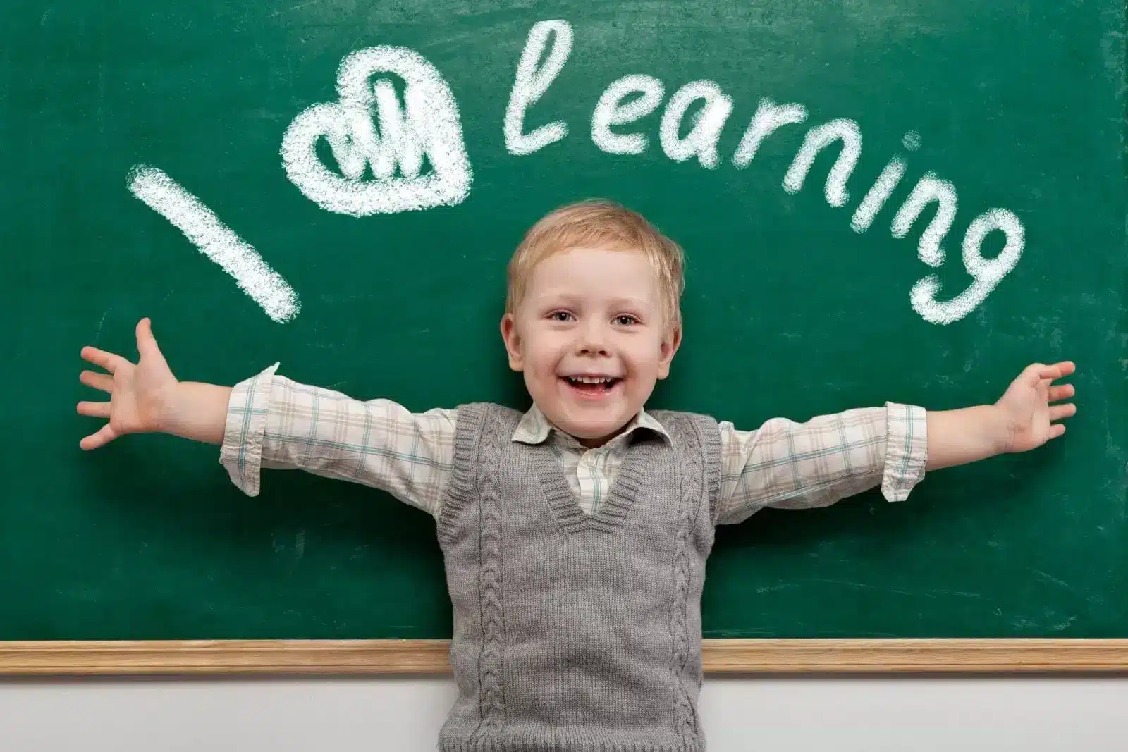 Boy with I Love Learning written in chalkboard behind