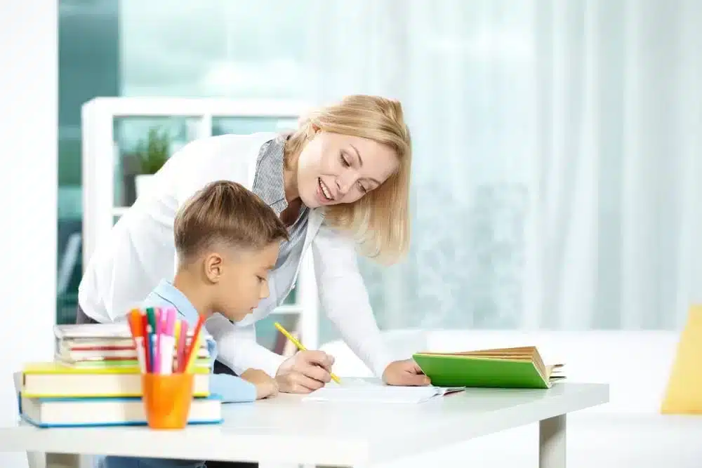 Mom teaching his son with pencil on the right hand