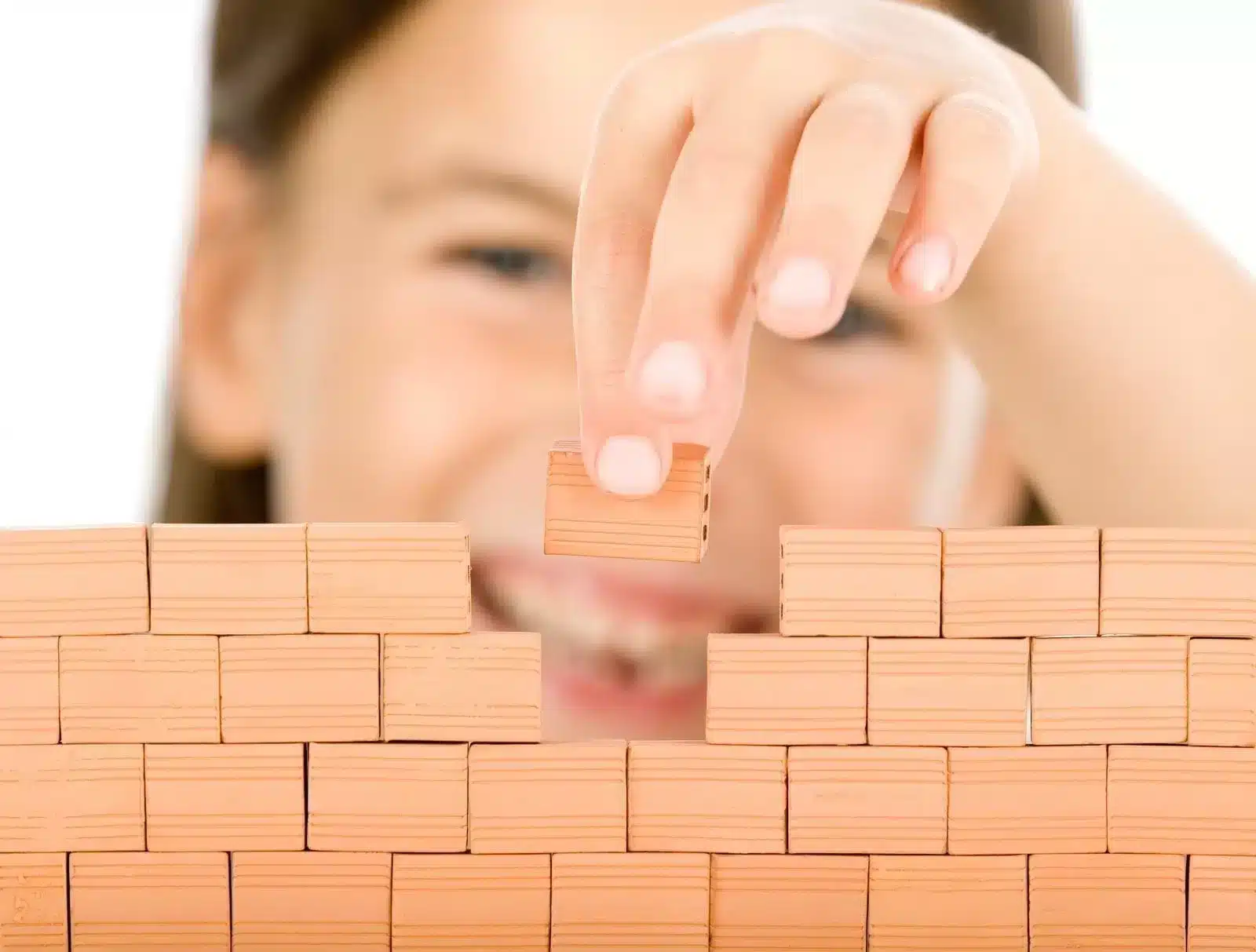 Child Building a Wall With Blocks