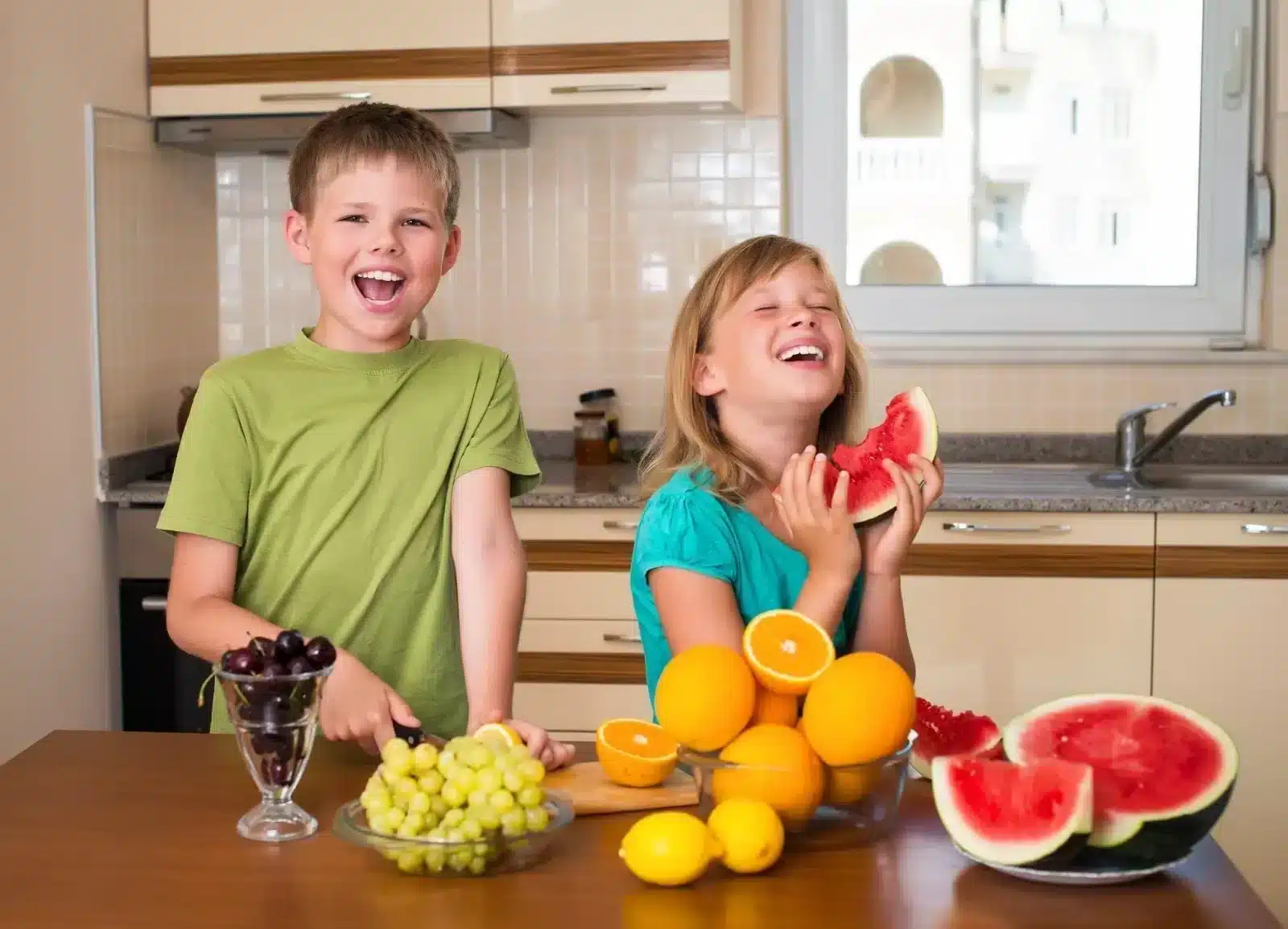 Boy and Girl in Kitchen eating fruit
